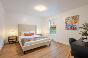 a white bedroom with a bed and a window at Spacious 3BR in the heart of Village in Montréal
