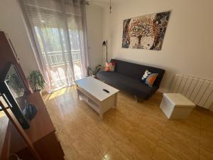 a living room with a couch and a table at Apartamento Bolboreta Playa Rodeira in Cangas de Morrazo