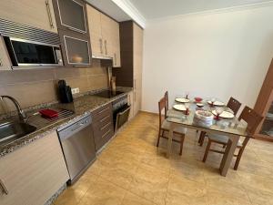 a kitchen with a table and chairs in a kitchen at Apartamento Bolboreta Playa Rodeira in Cangas de Morrazo