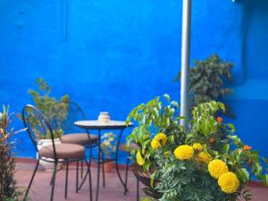 a patio with a table and chairs and yellow flowers at Dar SAAD in Rabat