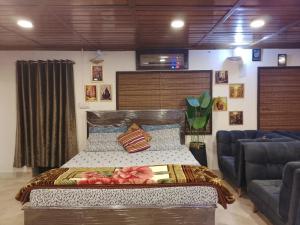 a large bed in a room with two chairs at White Bird Villa in Khaira Gali