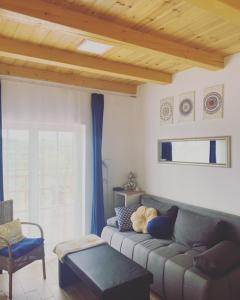 a living room with a couch and a chair at Eiross Apartmanház in Tamási