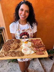 Una mujer sosteniendo una bandeja con alimentos para el desayuno. en Colonial zone great location private room, en Santo Domingo 34 fotos más