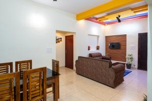 un soggiorno con un divano e un tavolo di CLUB 4 Homestay a Nedumbassery