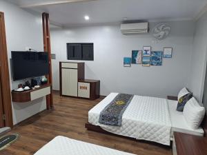 a bedroom with a bed and a flat screen tv at HOÀNG GIA LUXURy in Hanoi