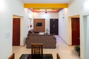 a living room with a couch and a tv at CLUB 4 Homestay in Nedumbassery