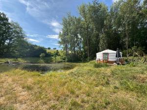 a yurt in a field next to a river at Jurta Lilly in Volenice