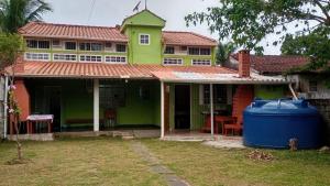 a house with a blue trash can in front of it at Praia de Boraceia casa 2 Bertioga in Bertioga