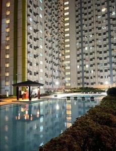 a large swimming pool in front of tall buildings at MPlace Tower D Condo Unit in Manila