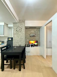 a dining room with a black table and a kitchen at MPlace Tower D Condo Unit in Manila