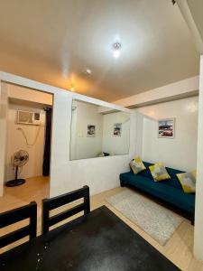 a living room with a blue couch and a mirror at MPlace Tower D Condo Unit in Manila +20 photos