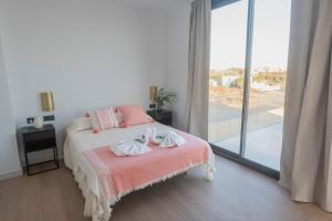 a bedroom with a bed with two towels on it at Villa Golf Isla Canela Links in Ayamonte
