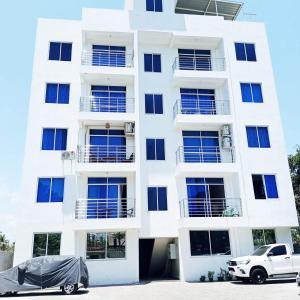 モンバサにあるNyali beach cosy homeの前に車が駐車されている白い建物