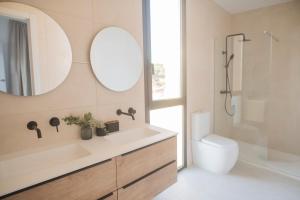 a bathroom with a sink and a toilet and a mirror at Villa Golf Isla Canela Links in Ayamonte +28 photos