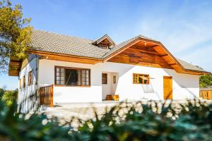 una casa blanca con una valla delante en VELINN Pousada Villa Paty II, en Campos do Jordão
