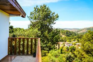 un balcón de una casa con vistas a los árboles en VELINN Pousada Villa Paty II, en Campos do Jordão