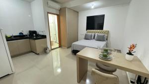 a room with a bed and a table and a kitchen at 303-4 · Studio Próximo UniEvangelica in Anápolis