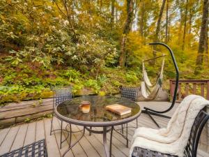 a patio with a table and chairs and a hammock at The Eagle's Nest Mountain Cabin Gatlinburg in Gatlinburg