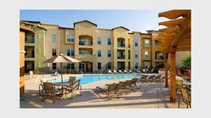 a pool with chairs and a table and a building at Mountain View #312 Surprise in Surprise