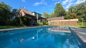 a swimming pool in front of a house at Villa in the forest of Amsterdam with Pool in Velsen-Zuid