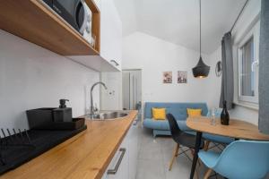 una cucina con un tavolo e un divano blu di Apartments by the sea Drasnice, Makarska - 24891 a Drasnice Altre 17 foto