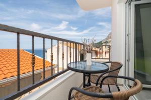 un tavolo e sedie su un balcone con vista sull'oceano di Apartments by the sea Drasnice, Makarska - 24891 a Drasnice