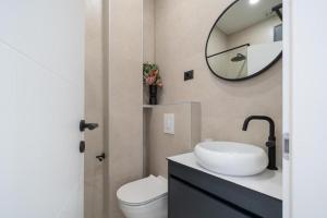un bagno con lavandino, WC e specchio di Apartments by the sea Drasnice, Makarska - 24916 a Drasnice Altre 9 foto