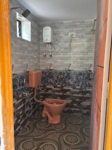 bagno con servizi igienici e muro di mattoni di Surabhi homestay a Gokarna