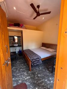 una camera da letto con un letto e un ventilatore a soffitto di Surabhi homestay a Gokarna