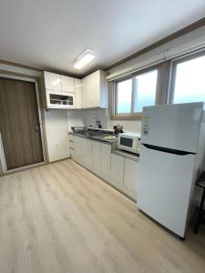a kitchen with white cabinets and a white refrigerator at Danaharu Guesthouse in Jeonju +52 photos