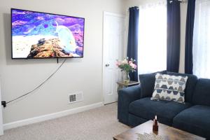 a living room with a tv hanging on a wall at One bedroom condo close to H St in Washington