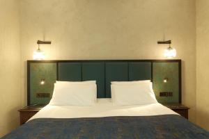 een slaapkamer met een groot bed met 2 witte kussens bij Hotel Indigo Batumi - Old Town by IHG in Batoemi