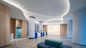 an office lobby with a blue chair and columns at Holiday Inn Express Haikou Int'l Duty Free City by IHG in Haikou