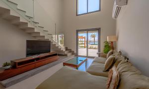 sala de estar con sofá, TV y escaleras en Shedwan, El Gouna, en Hurghada