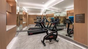 a gym with a row of treadmills and ellipticals at Holiday Inn Express Haikou Int'l Duty Free City by IHG in Haikou