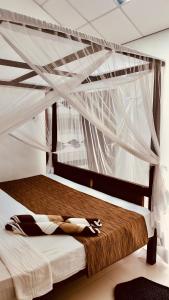 una cama con dosel en una habitación en DNA secret palace, en Tangalle