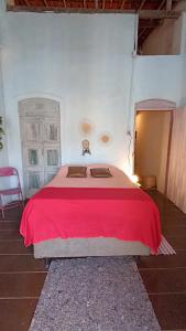 a bedroom with a large bed with a red blanket at Pelourinho House Experience in Salvador