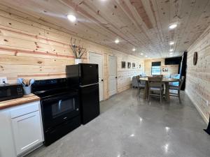 una cucina con frigorifero nero e tavolo di Bourbon Barrel Cottages #6 on Ky Bourbon Trail a Lawrenceburg