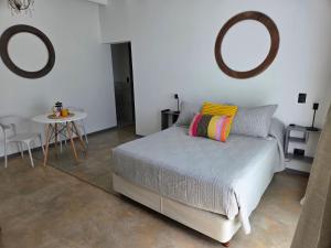 ein Schlafzimmer mit einem Bett, einem Tisch und zwei Spiegeln in der Unterkunft Patio Jarilla in El Challao