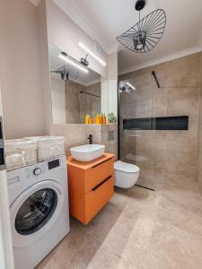Un baño con lavadora y lavabo. en Arya Apartment Oradea, en Oradea 37 fotos más