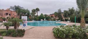 a swimming pool in a resort with trees and buildings at Atlas Golf Resort - Marrakech palmeraie a 6 k m du centre in Marrakesh