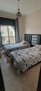two beds sitting in a room with a window at Atlas Golf Resort - Marrakech palmeraie a 6 k m du centre in Marrakesh +11 photos