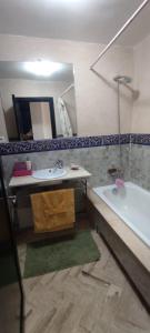 a bathroom with a sink and a tub and a mirror at Atlas Golf Resort - Marrakech in El Mgassem