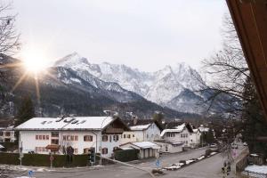 eine Stadt mit schneebedeckten Bergen im Hintergrund in der Unterkunft Ferienwohnungen Zur Wally, Apartment Sunnig in Garmisch-Partenkirchen + 1 Foto