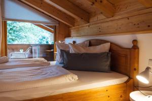 ein Schlafzimmer mit einem Bett mit einer Holzwand in der Unterkunft Ferienwohnungen Zur Wally, Apartment Sunnig in Garmisch-Partenkirchen