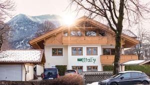ein Gebäude mit davor geparkten Autos in der Unterkunft Ferienwohnungen Zur Wally, Apartment Sunnig in Garmisch-Partenkirchen