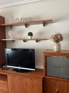 a living room with a tv on a wooden entertainment center at Beautiful apartment next to the historic center in Vigo