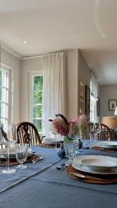 a dining room table with plates and glasses on it at Beautiful Villa & Garden in Munich in Munich +66 photos