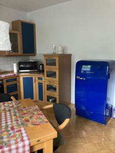 a kitchen with a table and a blue refrigerator at Premium Ruhiges ganzes Apartment 90 m 2 Schlafzimmer große Küche Wohnzimmer in Duisburg