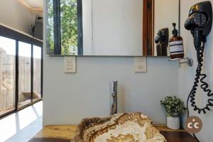 ein Badezimmer mit einem Spiegel an der Wand und einem Waschbecken in der Unterkunft Magnifico Loft para 2 con Vista al Mar de Zicatela in Puerto Escondido